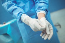 Male Surgeon Removing Surgical Gloves In Operation Theater