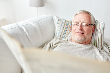 Sticker - close up of senior man reading newspaper at home