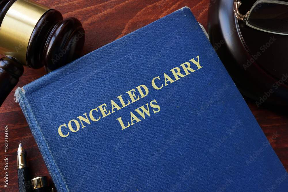 Concealed Carry Laws title on a book and gavel. - obrazy, fototapety, plakaty 
