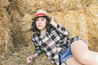 Mujer joven estilo country tumbada en el campo en verano