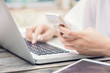 © kudosstudio - Female hands on laptop keyboard and smart phone