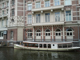 Netherlands, Amsterdam. Types of cities, buildings, canals and boats. Views on the water background. Amsterdam in the spring.