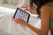 © DenisProduction.com - Female in bed with tablet. Lady's hand holding gadget. Ordering goods through site.