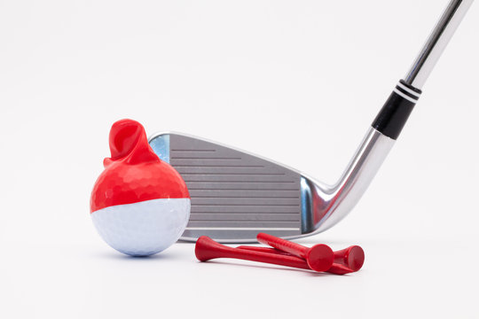 White golf ball with funny cap and golf club on the white backgr