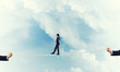 © adam121 - Business concept of risk support and assistance with man balancing on rope