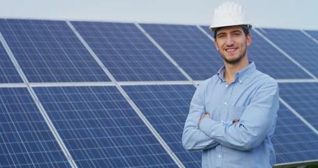 In a field of photovoltaic solar panels an engineer, check with tablet their operation with the sun, their cleanliness. Concept: renewable energy, technology, electricity, service, green power.