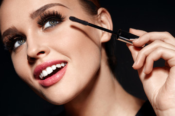 Wall Mural - cosmetics. beautiful woman with perfect makeup applying mascara