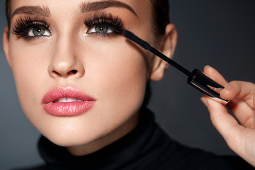 Wall Mural - beauty. beautiful woman applying black mascara on eyelashes