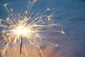 Wall Mural - sparklers burning on snow ground in winter