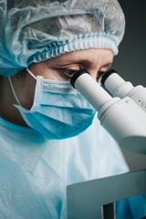 Wall Mural - close up view of scientist eye looking at microscope.