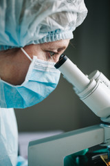 Wall Mural - close up view of scientist eye looking at microscope.