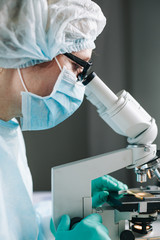 Wall Mural - close up view of scientist eye in glasses looking at microscope.