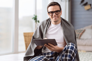 Delighted nice man holding a tablet