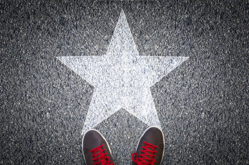 sneakers on asphalt road with white star