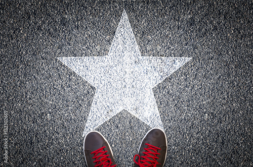 Fotomural Sneakers on asphalt road with white star