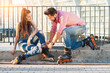 canvas print picture - Couple is wearing rollerblades. Man helping a woman. You're so kind to me.
