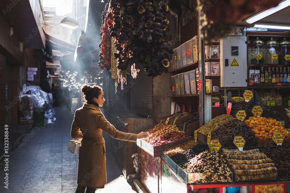 Woman chooses in the market nuts and dried fruit, the buyer trie - obrazy, fototapety, plakaty 