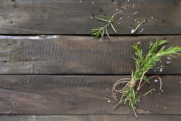 Sprigs of rosemary tied with string on a wooden table. Copy spac