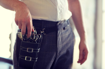 Poster - close up of male stylist with tool case at salon