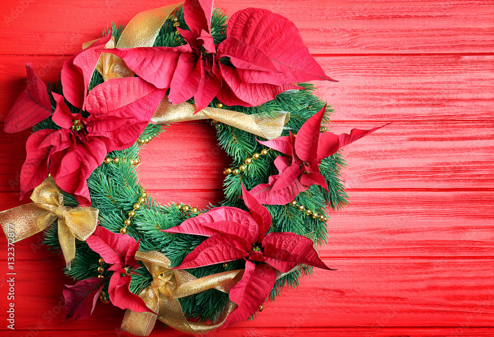 Beautiful Christmas wreath on red wooden background
