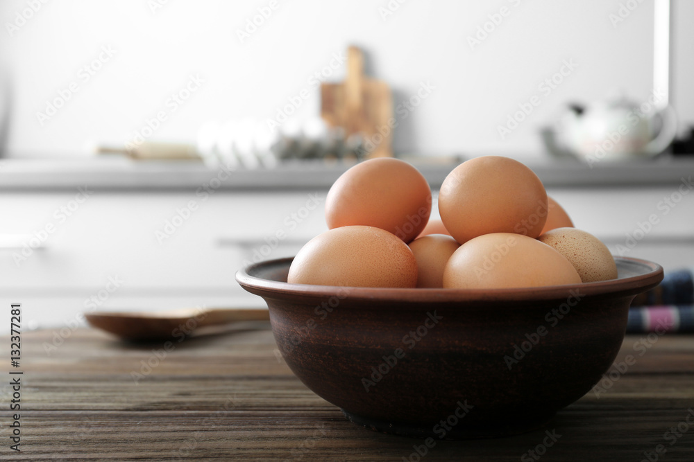 Raw eggs in bowl on kitchen table