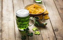 St. Patrick Day Concept. Glass Of Green Beer And Plate With Crisps On Wooden Table