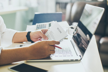 Business man review his resume on his desk, laptop computer, calculator and cup of coffee,Seleted focus.