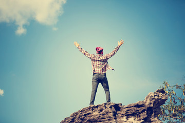 Wall Mural - Young tourist arms raised enjoying the fresh air top of mountain