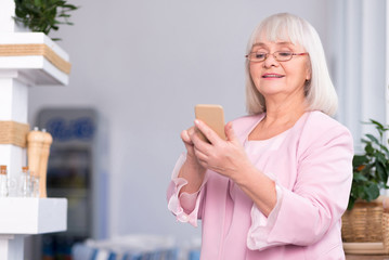 Excited senior woman using her phone