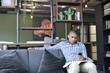 © Andy Paul - Informal black businessman with a mobile device in an office break out area