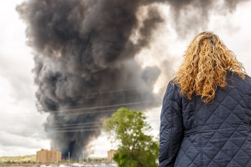 Wall Mural - A blond woman watching a big fire