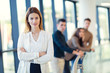 © Mediteraneo - Businesswoman posing while others business people talking in background