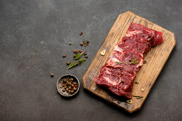 Wall Mural - Raw meat with spices and rosemary on wooden board. Fresh beef. Ready to roasting. Top view.