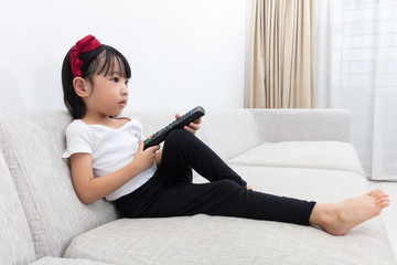 Wall Mural - Asian Chinese little girl holding a TV remote control