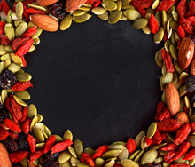 Nut Mix Snack With Raisins, Pumpkin Seeds, Almonds And Goji Berries On Stone Board