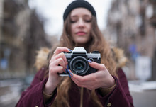 Hipster Girl Photographer With Retro Camera Taking Photo On City Street