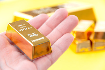 Hand hold gold bars