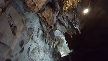 Movement Inside The Underground Cave With Overhanging Stalactites And Stalagmites In A Dark