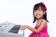 Leinwandbild Motiv Happy Asian Chinese little girl playing electric piano keyboard