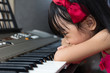 Leinwandbild Motiv Boring Asian Chinese little girl playing electric piano keyboard