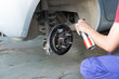 mechanic spray chemical to clean brake