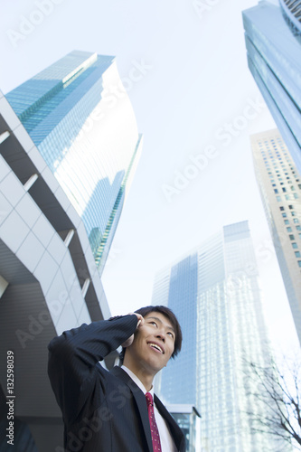 男性 ビジネスマン スマホ 会話 高層ビル背景 ローアングル 笑顔 和やか Stock Photo Adobe Stock