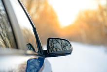 Close Up Image Of Side Rear-view Mirror On A Car In The Winter Landscape With Evening Sun