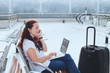© Song_about_summer - woman in airport talking by phone and checking emails on laptop, business travel, mobile wifi connection
