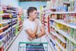 thoughtful man in the supermarket, customer thinking, choose what to buy, choice in shopping
