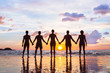 © Song_about_summer - community or group concept, silhouettes of people standing together and holding hands, team on the beach, unity background