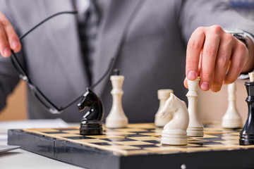 Young businessman playing chess in the office