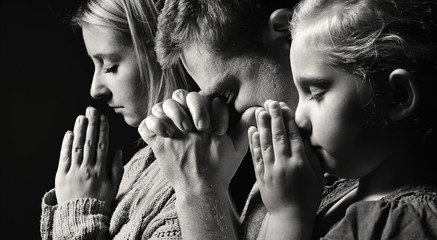 praying family. man, woman and child.