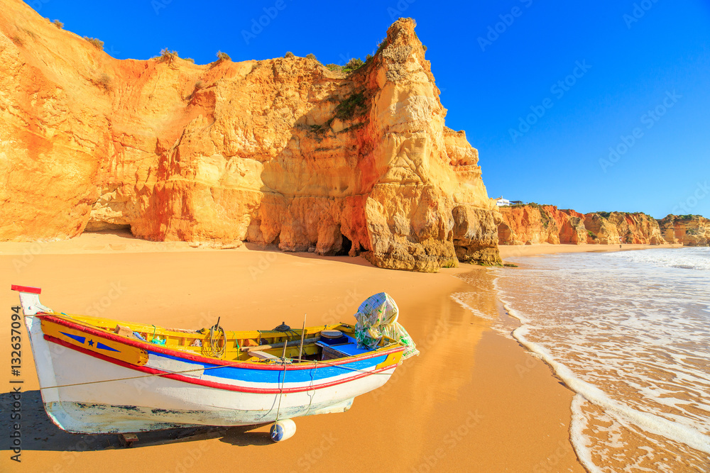 Fishing boat on a Praia da Rocha in Portimao, Algarve region, Portugal - obrazy, fototapety, plakaty 