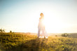 © serbinov - Young romantic woman on the meadow at sunset. The girl in the white dress enjoys the outdoors. Warm light . Strong glow of the sun behind the girl
